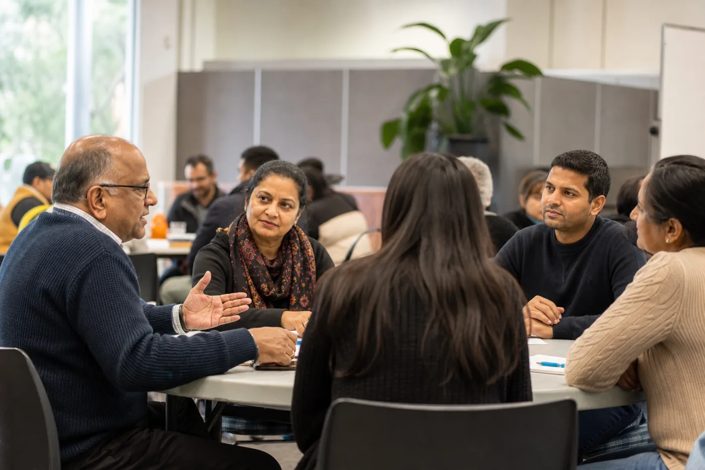 Indian Australian community members having a respectful discussion about migration and inclusion in an Australian community centre